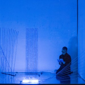  Come l’acqua che scorre. installazione crescente | azione performativa, 2021, bacchette di vetro dipinte, tubo al neon blu, sabbia, sassi, pavimento specchiante. Foto Dino Ignani