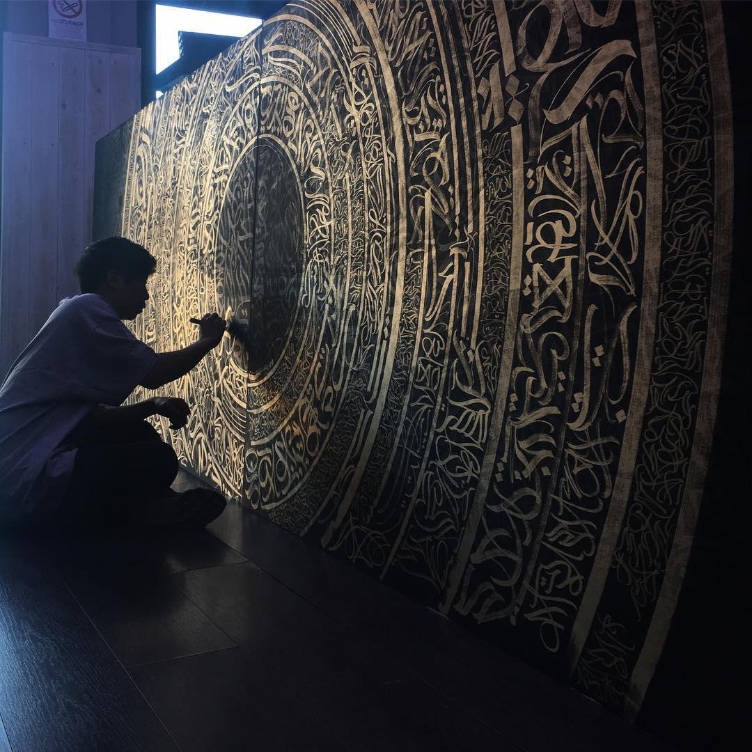 Patrick Eduardo working on “Osiris” Double black wood panel, 5 x 1.50 mt 